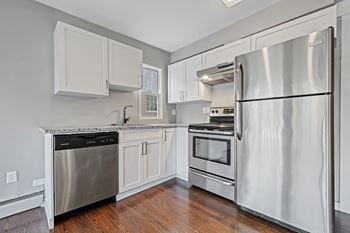 A kitchen with a stainless steel refrigerator, dishwasher, and oven.